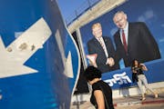 People walk by an election campaign billboard that shows Israeli Prime Minister Benjamin Netanyahu, right, and then-President Donald Trump, in Tel Avi