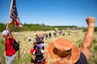 Indigenous leaders and "water protectors" marched through swamp land to the boardwalk leading to an Enbridge pipeline construction site on Monday.    