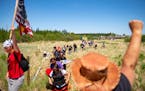 Indigenous leaders and "water protectors" marched through swamp land to the boardwalk leading to an Enbridge pipeline construction site on Monday.    