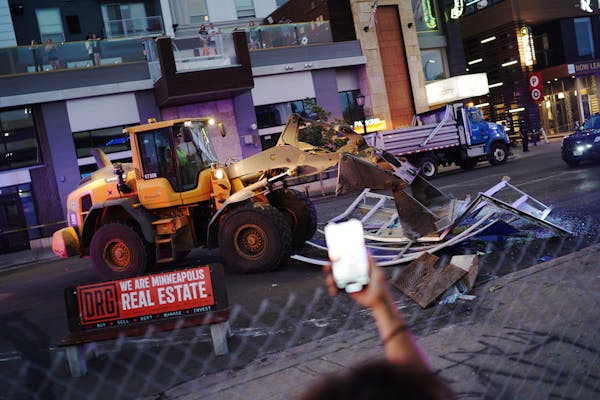 A loader cleared out barricades put up by protestors on W. Lake Street in Uptown on Tuesday in Minneapolis.