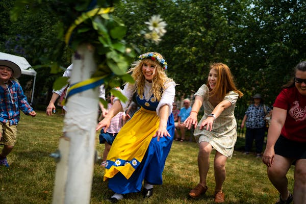 Sisters Natalie Redinger, center, and Heather Dewitt, right, participate in a traditional Swedish circle dance Thursday at the American Swedish Instit