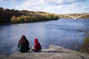 In this file photo from October 2020, people take in the view of the foliage along the Mississippi River near Shadow Falls Park in St. Paul. LEILA NAV