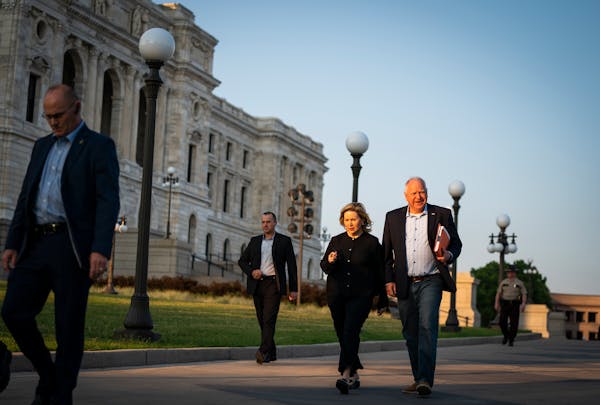 Gov. Tim Walz, with his wife, Gwen, walked the signed education budget law over to the office of Secretary of State Steve Simon on Wednesday.