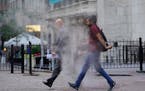 In this June 16, 2021 file photo, people walk through steam from a street grating during the morning commute in New York.