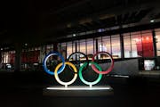FILE - In this Saturday, July 10, 2021, file photo, the Olympic rings are illuminated outside the Narita International Airport prior to the 2020 Summe
