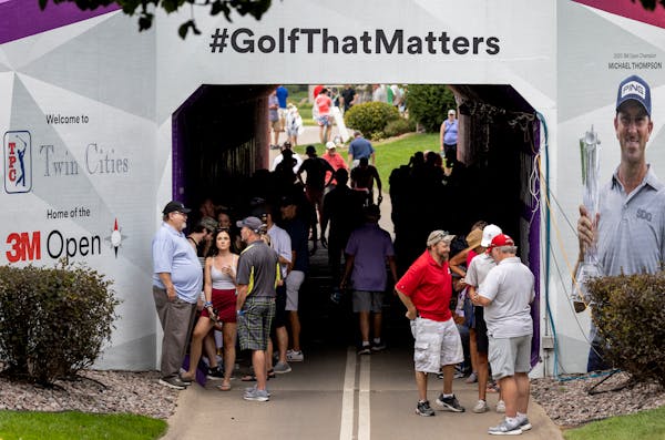 Fans gathered in a tunnel during a weather delay during the first round of the 3M Open in Blaine.