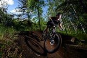 Kate Swanson, a helicopter flight nurse from Brainerd and avid mountain biker, cut around a berm on the “Drawpoint Trail” Tuesday at Cuyuna Countr