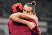 Gianmarco Tamberi, of Italy, embraces fellow gold medalist Mutaz Barshim, of Qatar, after the final of the men’s high jump at the 2020 Summer Olympi