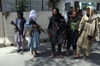 Taliban fighters stand guard at the main gate leading to the Afghan presidential palace Monday in Kabul, Afghanistan.