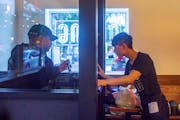 Food delivery drivers waited behind a designated low-contact window at Quang Restaurant in Minneapolis on Aug. 28.