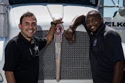 Joe Hernandez, general manager of the LKQ Corp. auto-parts distribution regional center in Fridley, with truck driver Davis Powell, who has worked his