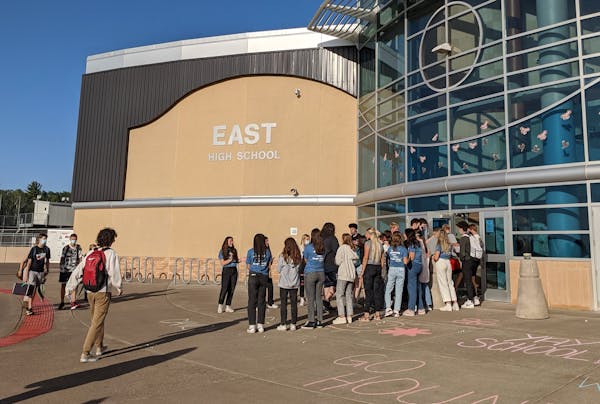 Duluth East High School’s Executive Board student group welcomes classmates back to school Tuesday morning with a human tunnel, candy and chalk mess
