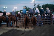 A bunch of cowboys on the sidelines watched the rodeo on the first night of the Hamel Rodeo in Hamel, Minn., on Thursday, July 8, 2021.