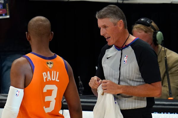 Referee Scott Foster talks with Phoenix Suns guard Chris Paul (3) before the start of Game 6 of basketball’s NBA Finals against the Milwaukee Bucks 