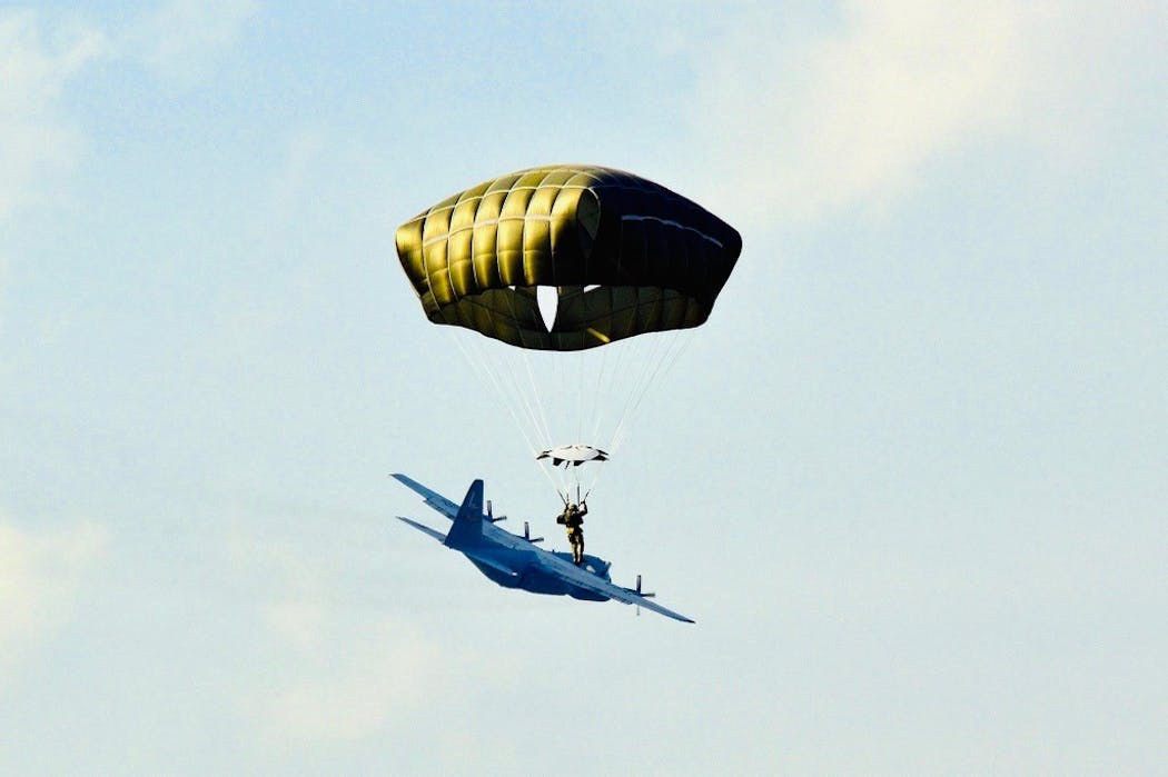 A member of the Minnesota National Guard parachutes out of a C-130 aircraft during a training exercise.