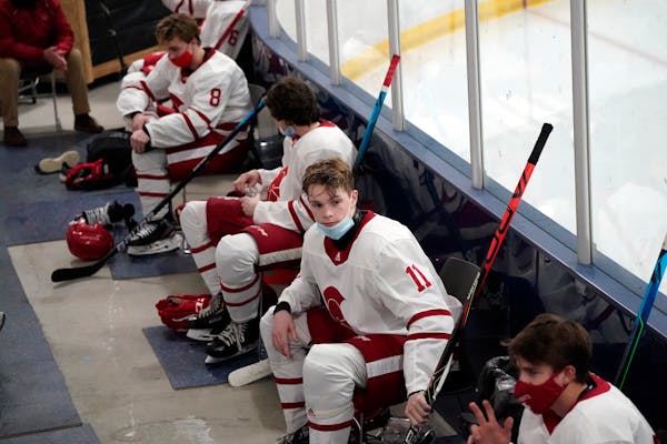 Benilde-St. Margaret’s players rested in a makeshift locker room area with social distancing in the arena last January.