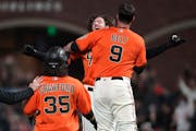 Kevin Gausman, rear, celebrated with Brandon Belt (9) after hitting a sacrifice fly that scored Brandon Crawford (35) during a Giants victory in Septe