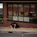 Minneapolis Police Department crime lab technicians identify the locations of shell casings on the sidewalk outside the Clientele Barber Shop in Minne