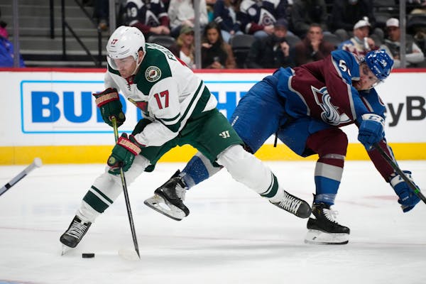 Wild left wing Marcus Foligno gets tangled up with Avalanche defenseman Kurtis MacDermid while driving to the net In the second period