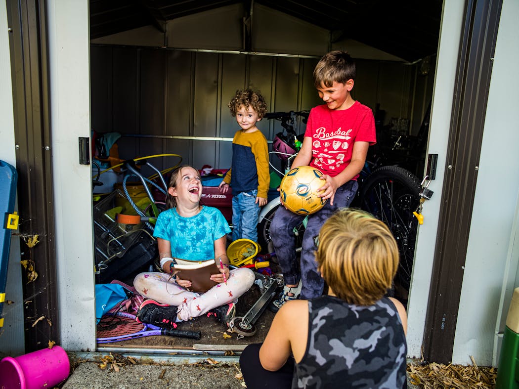 From left to right, Maggie McPherson, 9; Vinny Ruprecht, 4; and Ben Haugen, 9, hang out in the tool shed. The kids have grown close while getting to know one another through a social bubble that their parents created during the pandemic.