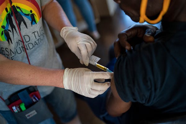 A nurse carries out trials of a COVID-19 vaccine at the Desmond Tutu HIV Foundation Youth Center in Masiphumelele, South Africa, Dec. 4, 2020. Moderna
