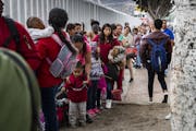Asylum-seeking immigrants line up at a border fence in Tijuana, Mexico on June 20, 2018. (Gina Ferazzi/Los Angeles Times/TNS)  IPTC information: