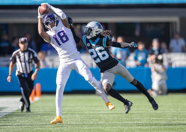 Vikings wide receiver Justin Jefferson (18) made a grab defended by Panthers cornerback Donte Jackson (26) during the fourth quarter, Sunday, October 