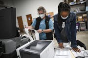 Election judges Kathy Bonnifield, left, and Bretaina Brigham on Friday confirmed the tabulated results from a batch of test ballots fed into a voting 