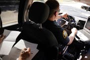 Licensed clinical social worker Amber Ruth, left, took notes on a case as St. Paul Police officer Justin Tiffany drove them to their next call in 2018