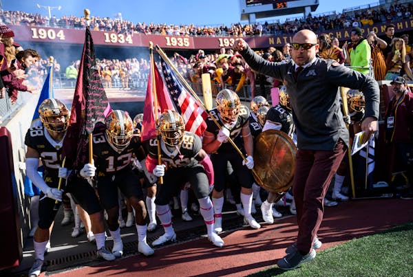 Gophers head coach PJ Fleck leads the team onto the field before the start of Saturday’s game
