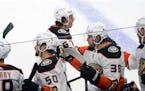 Anaheim Ducks’ Rickard Rakell, center, is congratulated at the bench after scoring against the Minnesota Wild during the first period. 