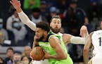 Minnesota Timberwolves center Karl-Anthony Towns drives against New Orleans Pelicans center Jonas Valanciunas in the first half of an NBA basketball g