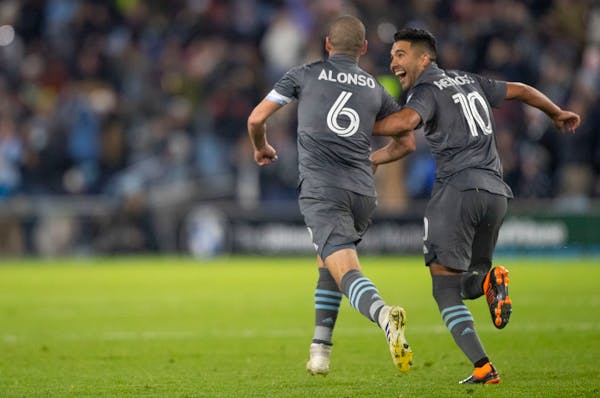 Minnesota United midfielder Emanuel Reynoso celebrates with Ozzie Alonso after Alonso scored the equalizer against Los Angeles FC