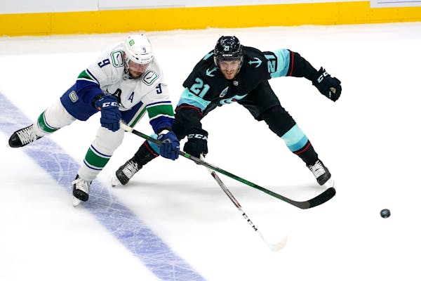 Vancouver’s J.T. Miller was met by Seattle’s Alex Wennberg during the Canucks’ victory on Saturday.