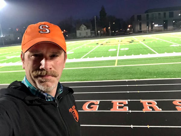 Minneapolis South High School principal Brett Stringer posed at his school’s football field lit up on April 6, 2020, as part of #BethelightMN during