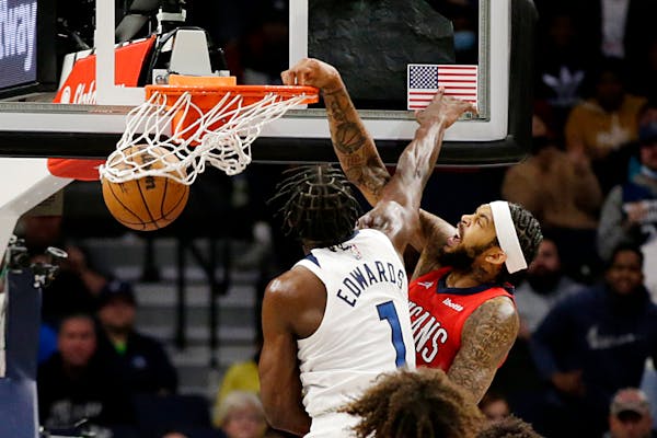 New Orleans Pelicans forward Brandon Ingram (14) dunks in front of Minnesota Timberwolves forward Anthony Edwards (1) in the second half of an NBA bas