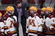 Brad Frost, middle, has a 418-87-35 career record as Gophers women’s hockey coach. 