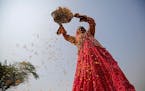 A woman winnows rice in a field on the outskirts of Ahmedabad, India.
