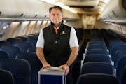 CEO Jude Bricker posed in his flight attendant attire on a Sun Country plane at Minneapolis-St. Paul International Airport.
