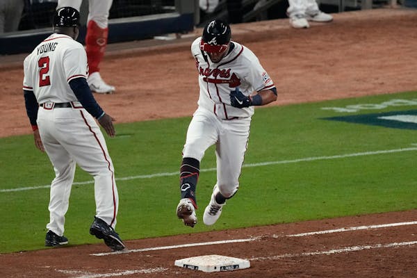 Atlanta Braves' Eddie Rosario runs past Atlanta Braves first base coach Eric Young Sr. after hitting a three run home run during the fourth inning in 