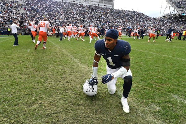 Penn State safety Jaquan Brisker (1) reacts as Illinois players celebrate their 20-18 victory after the ninth overtime of an NCAA college football gam