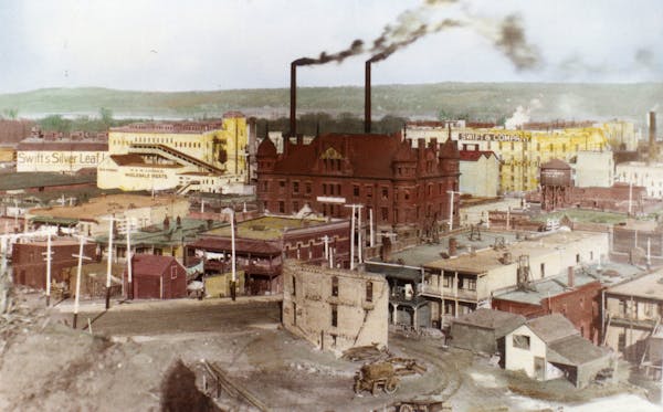 A hand-colored photograph of South St. Paul taken between 1912 and 1915. The structure at center is the Stockyards Exchange Building, which is still s
