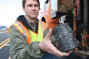 MnRoad operations engineer Ben Worel holds a core taken from an asphalt road in this 2005 file photo.