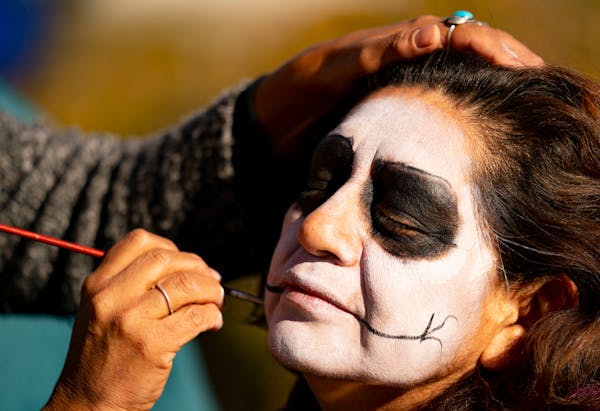 Columba Reyes has her face painted by Maria Cisneros before joining the Grito De Los Ancestros celebration that kicked off with a performance and pupp