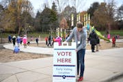 Josh Kiley, with the Ramsey County Elections Office, put out a “Vote Here” sign outside the Martin Luther King Recreation Center in St. Paul in 20