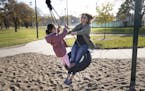 Molly Hauver plays on a tire swing with Nilofar Mulakhail’s (not pictured) daughter Maryam, 5, at a park in Bloomington, Minn., Friday, Nov. 5, 2021