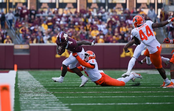 Minnesota Gophers running back Mar’Keise Irving (4) runs the ball for a first down as Illinois defensive back Tony Adams (6) gets the tackle during 