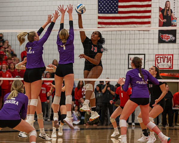 Eden Prairie middle blocker Kendall Minta (13) guides a shot past Chaska defenders Mallory Heyer (7) and Avery Rosenberg (4). Class 4A Section 2 volle