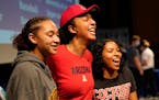 Hopkins High basketball standout Amaya Battle, left to right, posed for photos Wednesday with her high school teammates Maya Nnaji, who will play bask