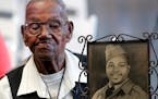 World War II veteran Lawrence Brooks holds a photo of him taken in 1943, as he celebrates his 110th birthday at the National World War II Museum in Ne